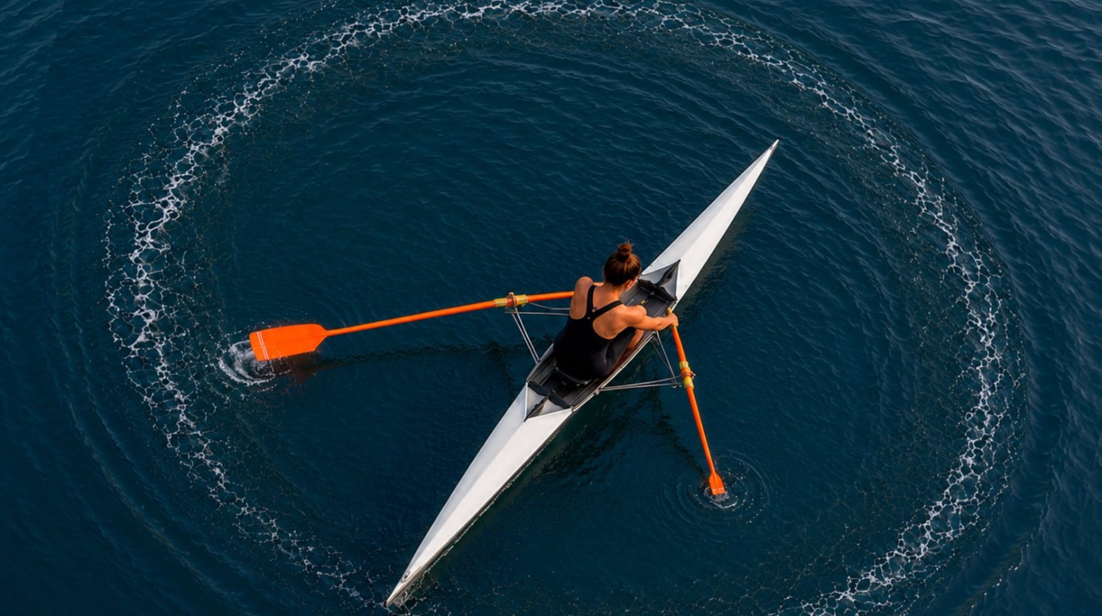 Aerial view of a sculler rowing in circles — one oar pulling hard on Phonics while the Language Comprehension oar barely touches the water — surrounded by the words Guessing, Word Calling, and Reading Comprehension.